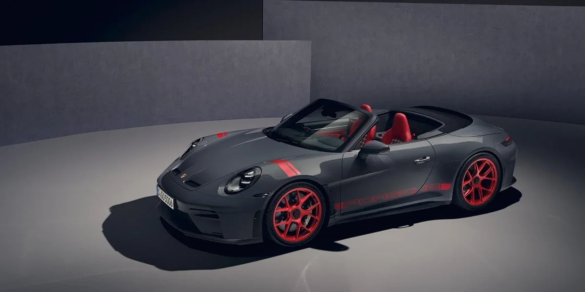 Grey Porsche 911 GT3 RS Cabriolet with red wheels shown from front three-quarter angle in studio.