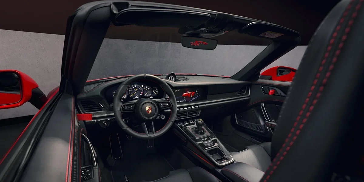 Interior of Porsche 911 GT3 RS Cabriolet showing dashboard, steering wheel, and digital display.
