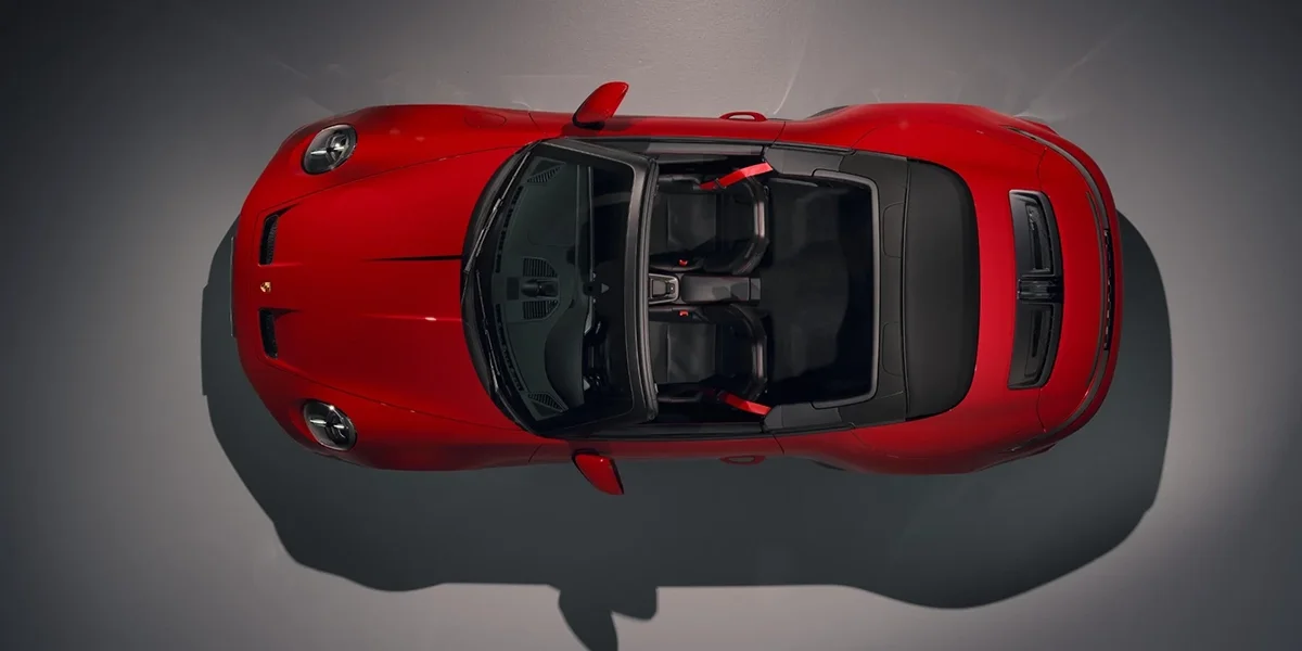 Top-down view of red Porsche 911 GT3 RS Cabriolet with open roof and dual seats.